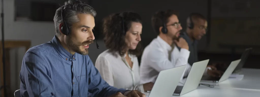 Pessoas olhando para os computadores em uma mesa de trabalho